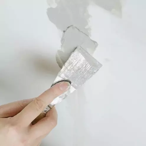 Man applying skim coat to dry wall