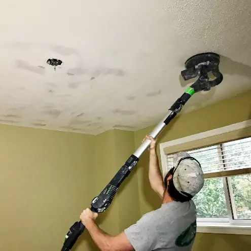 MR SKIMCOAT staff applying skim coat to a ceiling