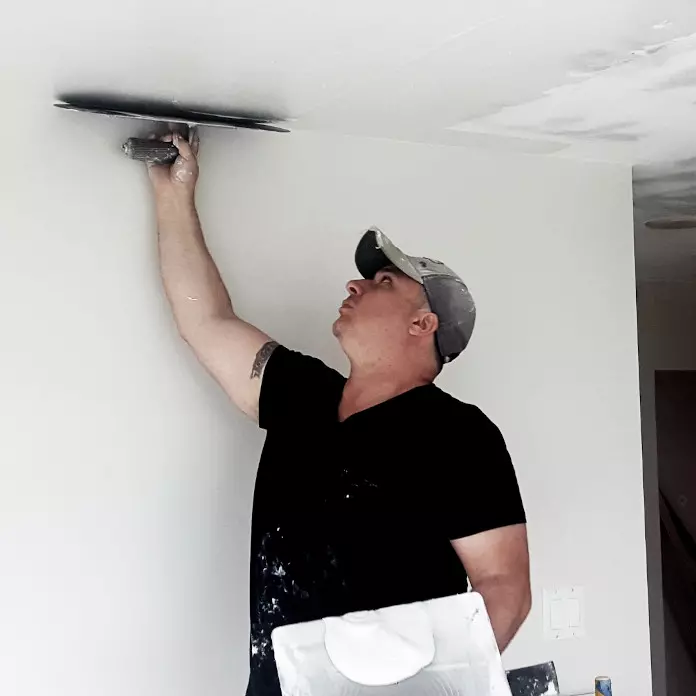 Applying skim coat to a wall